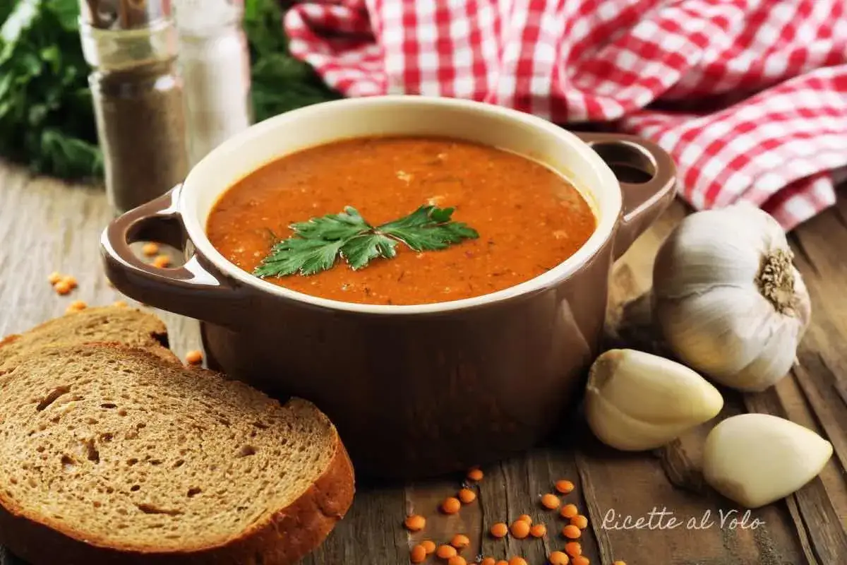 Zuppa cremosa di lenticchie decorticate, servita con pane integrale e aglio. Una ricetta facile e gustosa.