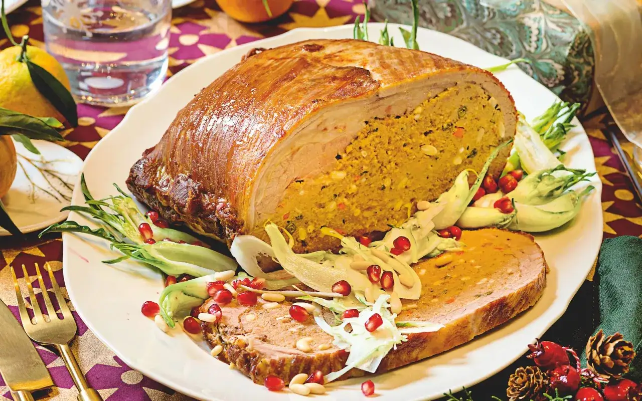Arrosto ripieno, un piatto perfetto per fare bella figura. Carne succulenta con un cuore dorato di verdure e spezie, guarnito con melograno e pinoli.