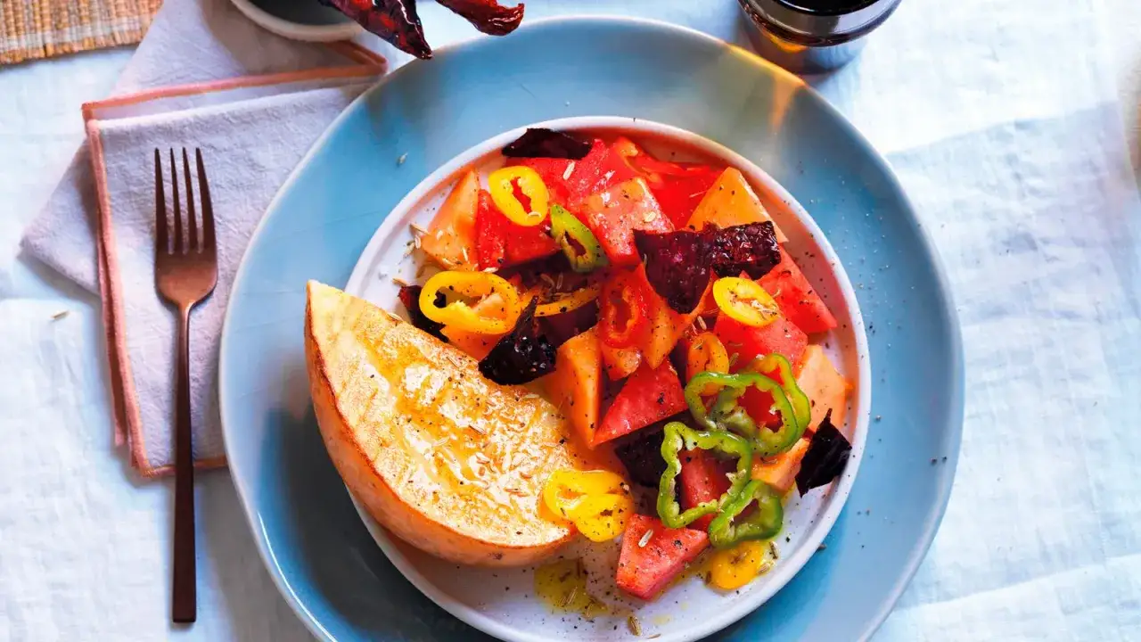 Insalata colorata con anguria, peperoni e una fetta di patata dolce grigliata. Un'idea fresca per le tue ricette con anguria.