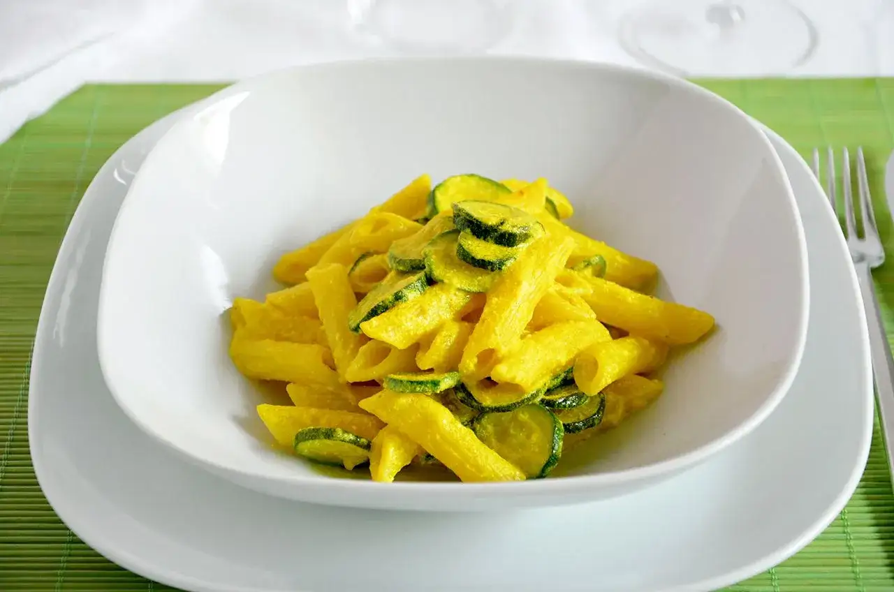 Penne gialle con zucchine, un modo gustoso per usare la curcuma nella pasta.