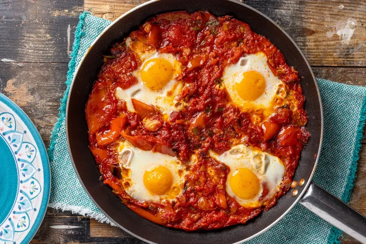 Uova in purgatorio in padella, un classico tra le ricette con uova, con pomodoro e peperoni.