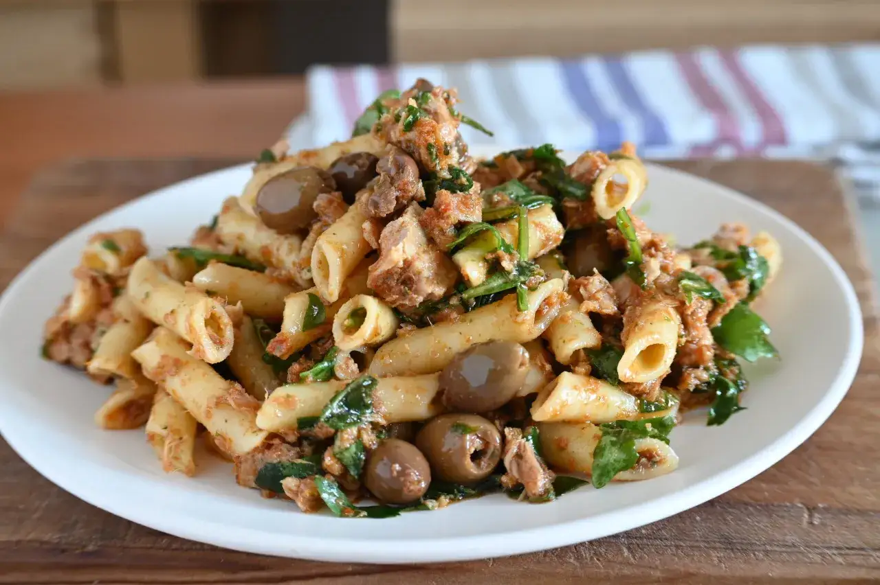 Piatto di pasta con tonno, verdure e olive taggiasche, un classico saporito.