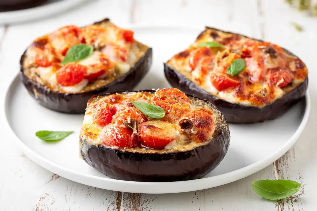 Melanzane ripiene al forno, un classico delle ricette con melanzane, con pomodorini e formaggio filante.