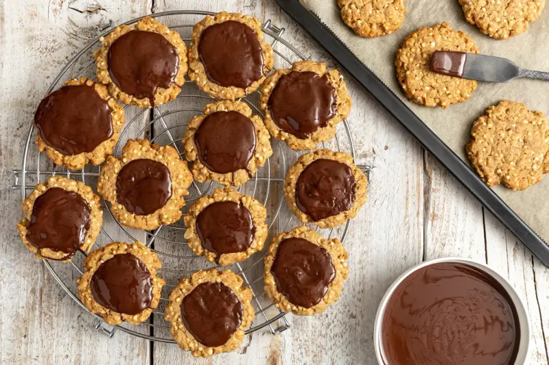 Deliziosi dolci con fiocchi di avena, alcuni ricoperti di cioccolato fuso, pronti per essere gustati.