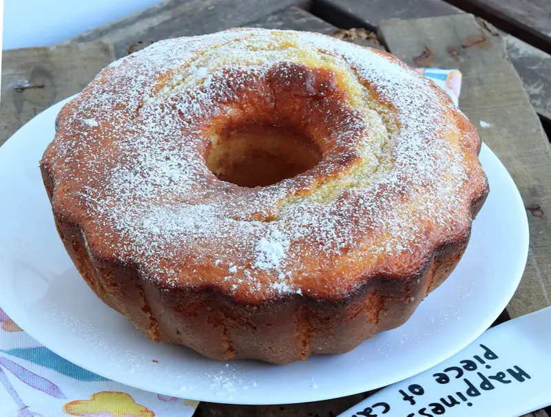 Ciambella soffice allo yogurt greco, cosparsa di zucchero a velo, pronta per essere gustata.