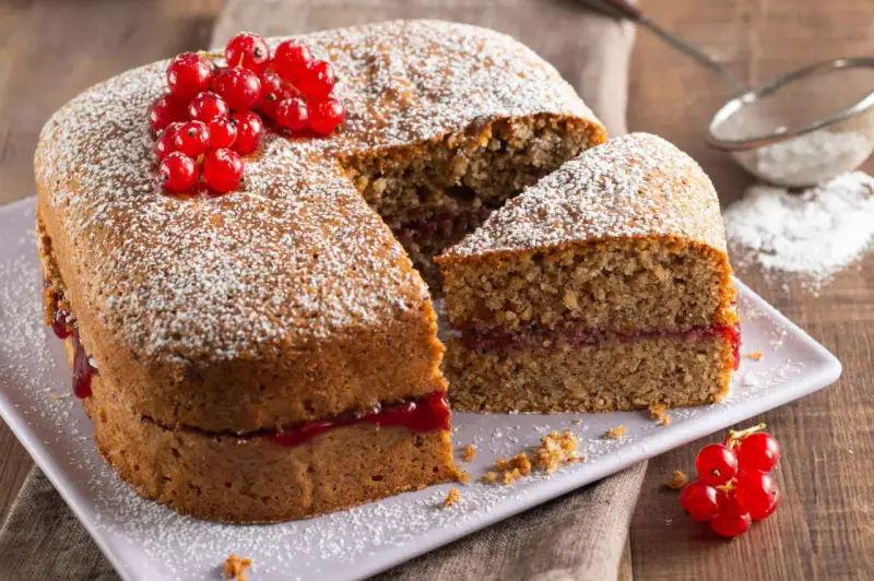 Torta di grano saraceno soffice, farcita con marmellata e decorata con ribes rossi e zucchero a velo.